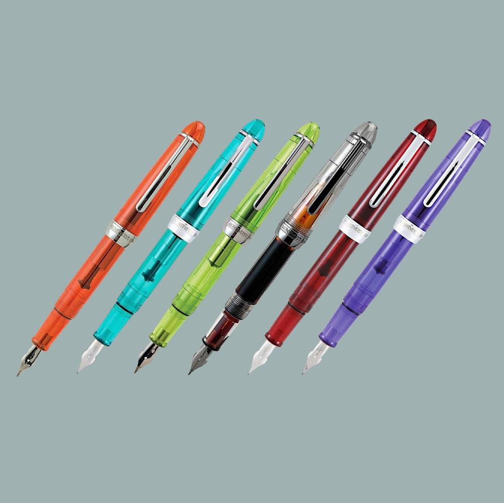 Row of six colourful transparent fountain pens with visible piston fillers, showing how to use a fountain pen