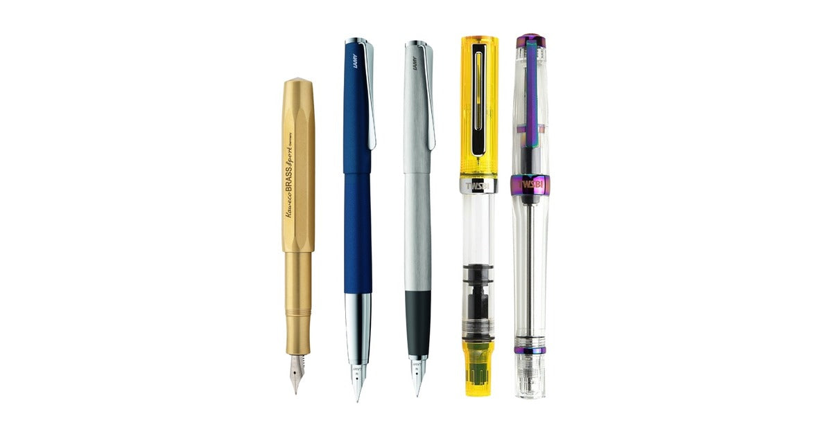 Five fountain pens standing upright: a Kaweco Brass Sport, two Lamy Studio pens and two clear TWSBI pens